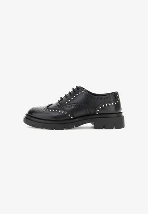 Schwarze Leder-Oxford-Schuhe mit dekorativen Perforationen und metallischen Nieten, ausgestattet mit einer dicken schwarzen Sohle und traditionellem Schnürdesign.