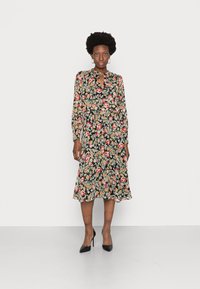 Vestido preto com estampa floral, apresentando mangas longas, decote em forma de chave e uma silhueta fluida em A, com padrões em vermelho, rosa e verde.
