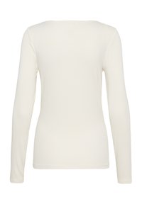 Top cu mâneci lungi, ajustat, de culoare crem deschis. Material moale și elastic, cu un design simplu și decolteu rotund. Fără accente sau modele vizibile.