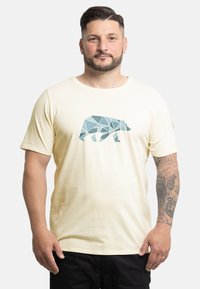 Cremfarbendes T-Shirt mit einem geometrischen Bärendesign in Blautönen. Weicher Stoff, kurze Ärmel und runder Hals. Logodetail auf dem Ärmel.