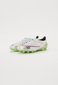 Witte en iriserende voetbalschoenen met zwarte accenten. Kenmerken zijn lichtgewicht materiaal, een contoured vorm en felgroene rubberen noppen.