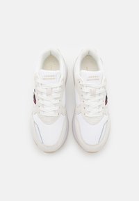 Białe sneakersy z teksturowaną cholewką z materiału, z akcentami z zamszu i gumową podeszwą. Posiadają sznurowadła oraz etykietę z logotypem na języku.