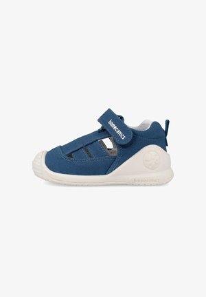 Blauwe sandaal voor peuters met witte zool, gesloten neus, open zijkanten en verstelbare klittenbandsluiting met label "biomecanics".
