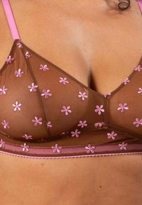 Ruskea verkkomuotoilu bralette, jossa on vaaleanpunaisia kukkakirjontoja, ohuet vaaleanpunaiset hihnat ja herkät reunat. Ominaisuuksiin kuuluu pehmeä tekstuuri ja kolmiomainen muoto.