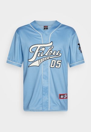 Lys blå baseballtrøye med korte ermer, knappestolpe, svart og hvit "Fubu League" skrift, og en rød etikett nederst til høyre.