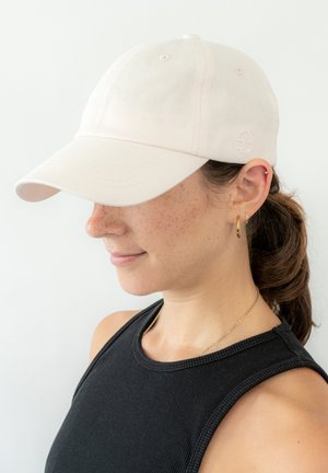 Cappellino da baseball rosa chiaro in tessuto di cotone con visiera curva, caratterizzato da un dettaglio del logo ricamato e sei occhielli di ventilazione nella parte superiore.