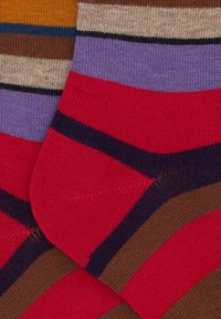 Striped socks featuring red, purple, brown, and yellow colors with horizontal bands; made of soft material, showcasing a knit texture.