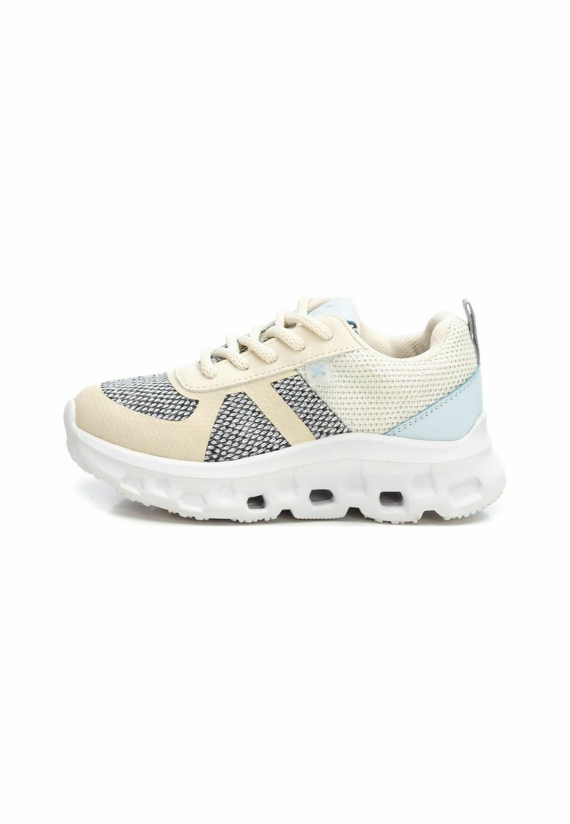 Zapatillas con una parte superior de malla beige, acentos en gris y azul, y una suela blanca gruesa que presenta agujeros de aire para amortiguación.