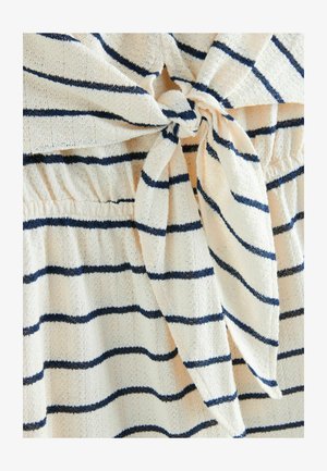 Biała tkanina z granatowymi poziomymi paskami, z węzłowym detalem w talii i teksturowanym, lekkim materiałem.