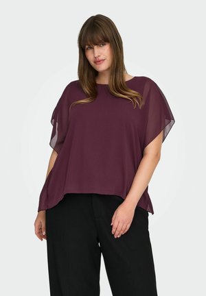 Haut fluide bordeaux avec des manches courtes transparentes et une coupe décontractée, associé à un pantalon noir. Tissu léger avec une texture lisse.