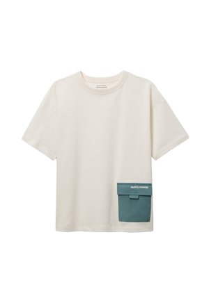 T-shirt crème à manches courtes avec une grande poche verte sur le bas à gauche, étiquetée "PASTEL POWER" sur le rabat.