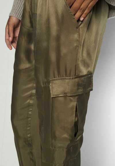 Olive green satin trousers with a smooth texture, featuring a side cargo pocket and a relaxed fit. The fabric has a subtle sheen.