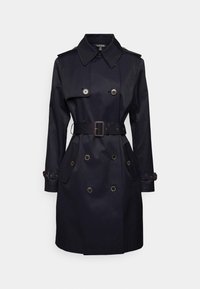 Marinblå trenchcoat tillverkad av vattentätt tyg, med dubbelknäppta knappar, midja med bälte, stora fickor och slagkrage.