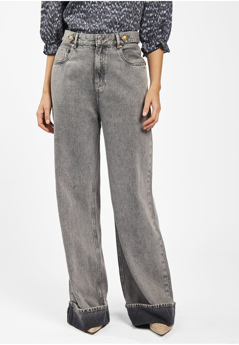 Brede, high-waisted jeans in een vervaagd grijs denim. Voorzien van goudkleurige hardware, klassiek vijf-pocket ontwerp en contrasterende donkere manchetten.