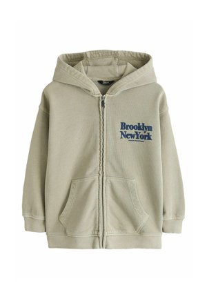 Béžová mikina na zips s kapucňou, predné vrecká a modrý nápis "Brooklyn New York" na ľavej strane hrudníka.