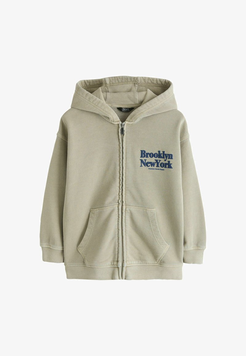 Sweat-shirt à capuche beige à fermeture éclair intégrale avec poches avant et texte "Brooklyn New York" en bleu sur le côté gauche de la poitrine.