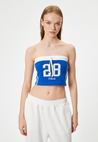 Top corto sin mangas de color azul con una banda blanca en la parte superior, que presenta el número "28" y "ITALIA" impresos en blanco. Material de algodón texturizado.