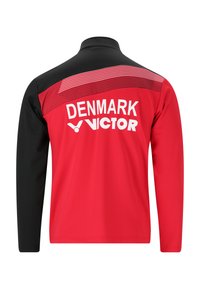 Rød og sort langærmet sportsjakke med hvid tekst "DENMARK" og "VICTOR" på ryggen samt et stribet rødt design på skuldrene.