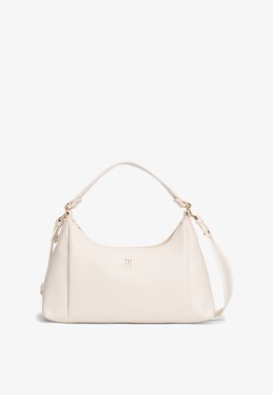 Ramena torba od kremasto obojene kože sa zlatnim logotipom i okovima, s gornjom ručkom i podesivim remenom za rame.