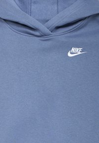 Sweatshirt azul da Nike em tecido macio, com um bolso canguru e logo branco no peito, além de capuz ajustável com cordão.