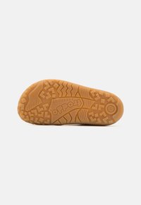 Talpă din cauciuc cu modele texturate pentru aderență, de culoare maro deschis, având logo-ul "Froddo" și marcajul de dimensiune. Design durabil și flexibil.