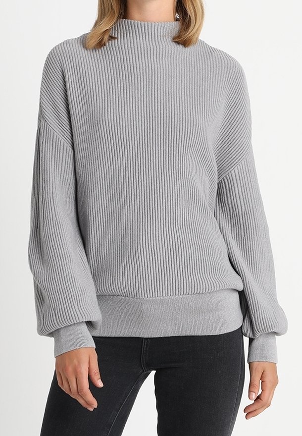 Pull gris clair côtelé avec un col montant, des épaules tombantes et des manches larges. Texture douce avec une taille ajustée. Style décontracté.