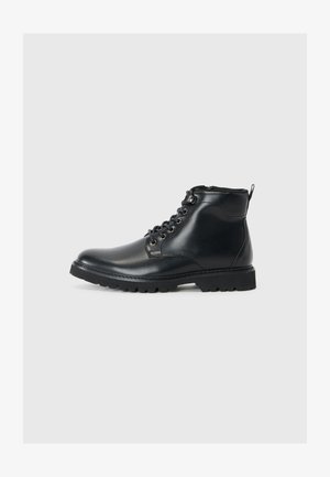 Schwarze Leder-Stiefeletten mit runder Spitze, Schnürverschluss vorne, strukturierten Seiten und einer robusten Sohle für besseren Halt. Mit einer Schlaufe hinten zum leichteren Anziehen.