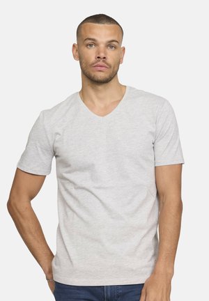 T-shirt gris à manches courtes en V en coton, avec une texture douce et un design simple. Porté avec un jean bleu.