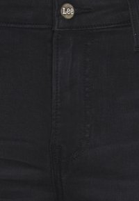 Jeans de mezclilla negra con un botón con el logo de Lee. Presentan un diseño de cinco bolsillos, costuras resistentes y una textura elegante y suave.