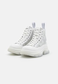 Białe wysokie sneakersy z masywną przezroczystą podeszwą, z siateczkową cholewką, płaskimi sznurowadłami oraz akcentami logo na języku i pięcie.