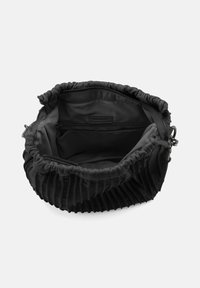 Borsa in pelle nera con parte superiore arricciata, texture a righe e fodera in tessuto. L'interno presenta una tasca con zip e un'etichetta con logo.