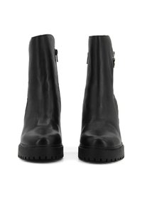 Stivaletti neri in pelle con finitura liscia, dotati di cerniere laterali e suole in gomma spessa e testurizzata per una maggiore aderenza.