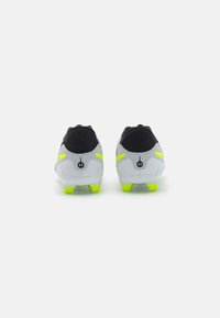 Crampons de football en gris et noir, avec des accents jaune néon et une surface texturée. Présentent un design épuré et des crampons moulés.