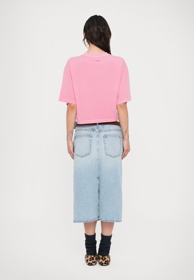 Ροζ κοντομάνικο μπλουζάκι σε cropped γραμμή σε συνδυασμό με ανοιχτό μπλε τζιν φούστα. Μαύρα πλεκτά καλσόν για τα πόδια και παπούτσια με λεοπάρ σχέδιο ολοκληρώνουν την εμφάνιση.