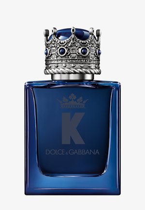 Flacon de parfum en verre bleu avec un bouchon couronne en argent détaillé présentant des pierres bleues et la lettre K à l’avant.