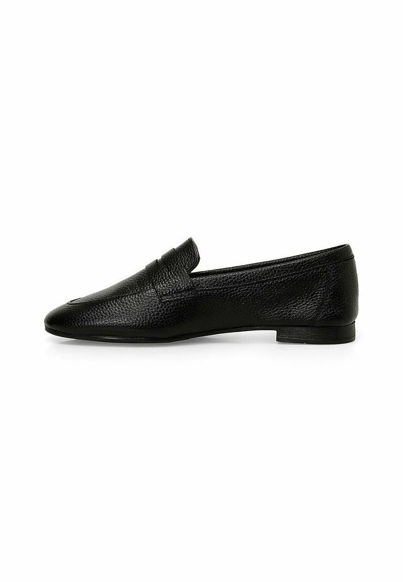 Mocassino in pelle nera con finitura texturizzata, punta affilata e tacco basso. Presenta un design semplice senza hardware visibile o motivi.