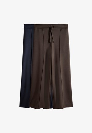 Dos pares de pantalones de corte suelto y pierna ancha con cintura de cordón, uno marrón oscuro y otro azul oscuro, exhibidos extendidos sobre un fondo blanco.