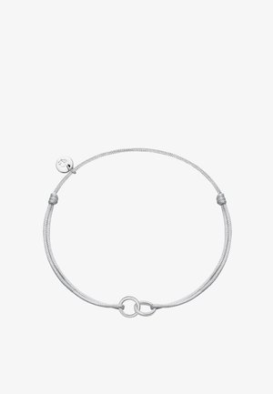 Silbernes verstellbares Cordarmband mit zwei ineinandergreifenden Ringen und einem kleinen runden Anhänger, der mit einem Herzsymbol graviert ist.