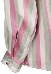 Poignet de blouse à manches longues avec des rayures verticales roses, blanches et vertes, doté d'une fermeture à bouton doré et d'une texture de tissu douce.