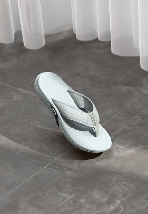 Chanclas de color gris claro hechas de goma con una suela texturizada, que presentan dos correas grises y un pequeño logo en la correa superior.