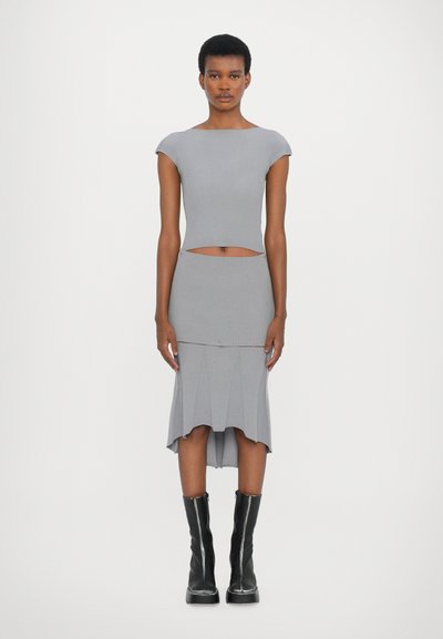 Ensemble bi-matière gris à côtes comprenant un haut ajusté à manches courtes et une jupe crayon taille haute avec des détails de ourlet plissé. Longueur genoux.