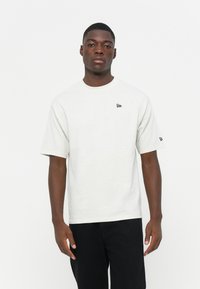 Light gray short-sleeve t-shirt made from cotton, featuring a round neckline and a small black logo on the left chest area.
