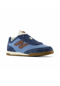 Blue and navy suede and mesh sneaker with a brown logo, white accents, and a rubber sole, featuring a lace-up design and padded collar.