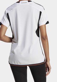 White sports jersey with black mesh side panels, orange accents, and "DEUTSCHLAND" label at the back neck. Short sleeves, relaxed fit.