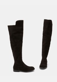 Botas de ante negras altas hasta la rodilla con suela plana y puntera redondeada. Presentan una textura suave y un diseño minimalista sin herrajes visibles.