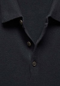 Polo en tricot bleu marine avec un tissage texturé, doté d'un col et de trois boutons marron au niveau du col.