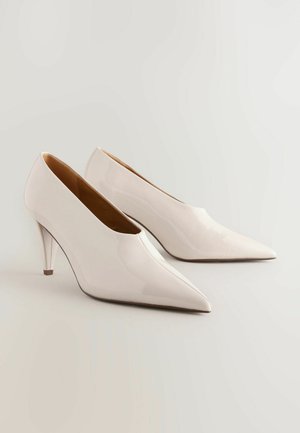 Glossy white high-heeled shoes with a pointed toe and a slim stiletto heel. Smooth surface and minimalistic design.
