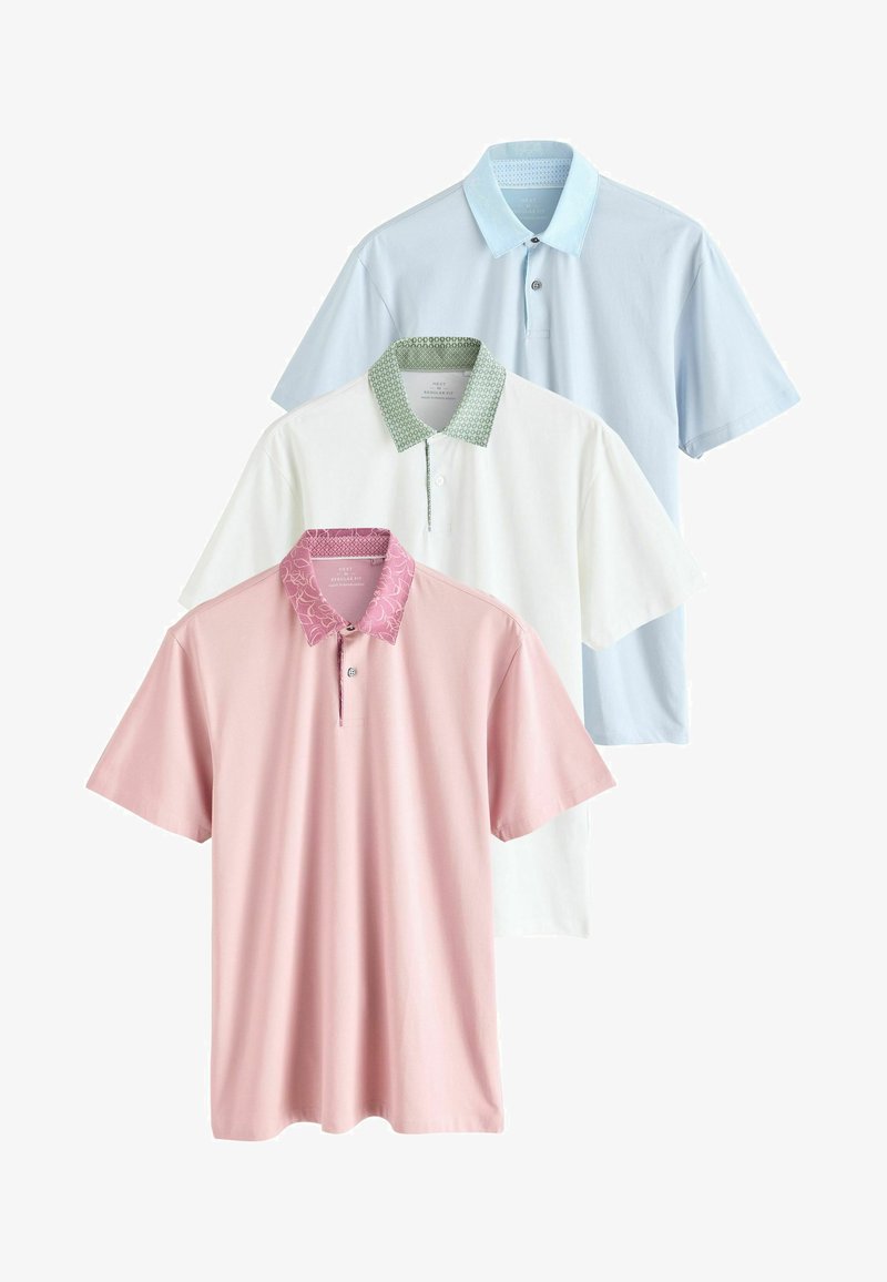 Tre polo skjortor i ljusblått, vitt och rosa. Var och en har en distinkt krage: blå med ett mönstrat kantband, grön geometrisk och rosa blommönstrad.
