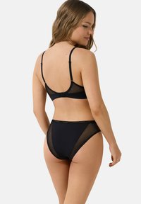 Zwarte lingerieset met een BH met mesh achterzijde en verstelbare bandjes, en bijpassende hoogzitpanty met mesh zijkanten.