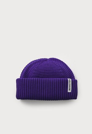 Purple knit beanie with a ribbed texture and foldable cuff. Features a small white tag with "SALOMON" branding on the side.